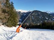 Enneigement par canons à neige sur la piste de descente vers la vallée
