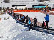 Le tapis roulant sur la prairie du village transporte les débutants et les lugeurs.