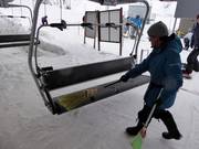 Le siège est balayé avec un balai pour enlever la neige à l’embarquement.