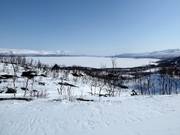 La partie inférieure du domaine skiable avec vue sur le lac Torneträsk long de 70 km