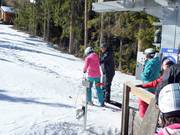 Le personnel aide à monter sur le téléski à assiette.