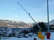 Enneigement par canons à neige sur la piste de descente vers la vallée