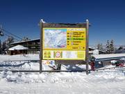 Panneau d'information avec plan des pistes dans le domaine skiable