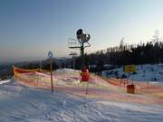 Canon à neige sur la piste de descente vers la vallée